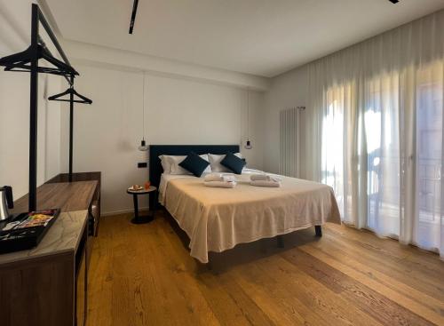 切法卢B&B Le Suites di Costanza的一间卧室设有一张大床和一个大窗户