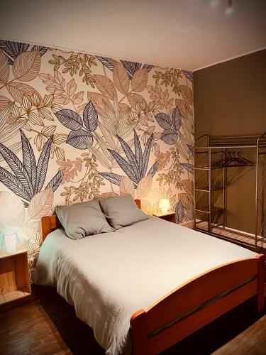 圣迪耶Petit prince chambre à louer的一间卧室配有一张带花卉墙壁的床