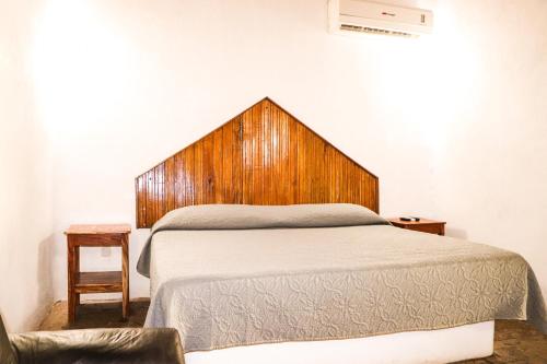 特科曼San Rafael的一间卧室配有一张带木制床头板的床