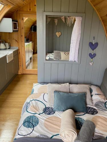 BoncathGarden Cottage Glamping Pod的一张位于带镜子的小房子里的床位