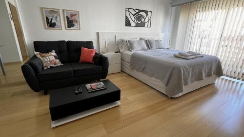 布宜诺斯艾利斯Petite Maison II的一间卧室配有一张床、一张沙发和一把椅子