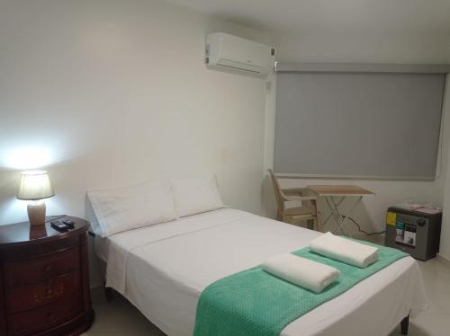 巴拿马城Doña Nancy的一间卧室配有一张床,上面有两条毛巾
