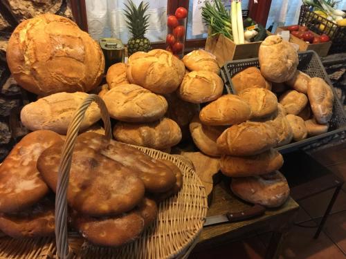 拉斯马哈达斯Alojamientos Turisticos La Utrera的桌子上放着一大堆面包和面包