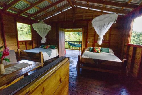Marigot罗茨丛林仙境酒店的木屋内设有一间带两张床的卧室