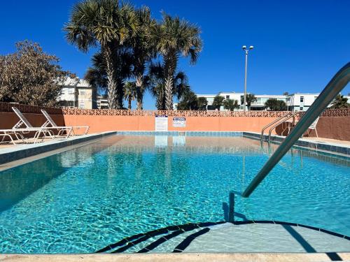 彭萨科拉海滩Gulf Front Penthouse Condo的一个带椅子的游泳池,棕榈树