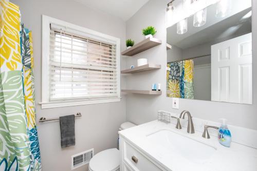 夏洛特Carolina Blue-Roomy 3BR One and One Half Bath Great Space For Smaller Families的一间带水槽、卫生间和镜子的浴室