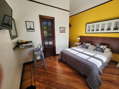 布宜诺斯艾利斯Habitaciones en Suite Balcarce的一间卧室设有一张床和黄色的墙壁