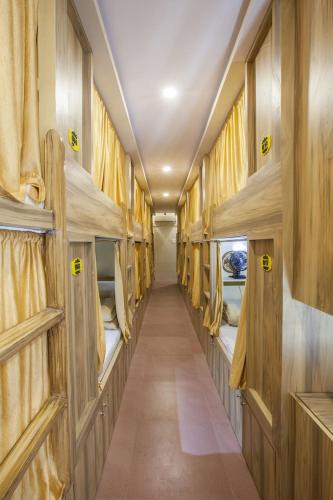 孟买New Abza Dormitory的一条带双层床的空火车车厢的走廊