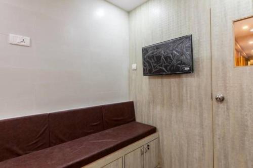 孟买New Abza Dormitory的一间设有长凳和墙上一幅画的等候室
