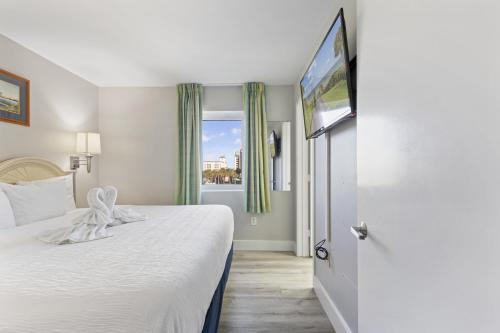 默特尔比奇Oceanfront Condo in Atlantica Resort near Boardwalk的酒店客房,配有床和电视