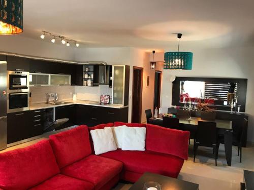 尼亚普拉莫斯Peramos Luxury的一间带红色沙发的客厅和一间厨房