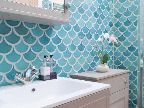 特雷弗戈恩Tucking Cottage的浴室设有白色水槽和蓝色的墙壁