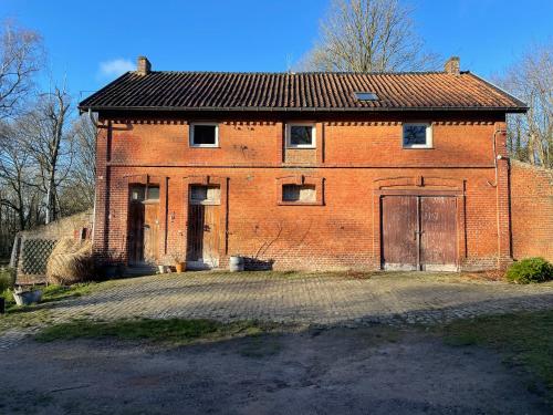 Sart-Dames-Avelines公鸡马厩乡村民宿的一座旧红砖建筑,有两个门