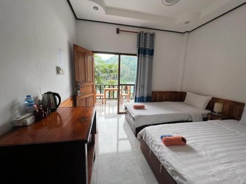 NongkhiawNongkhaiw river view的带两张床和一张书桌的房间和一个带窗户的房间