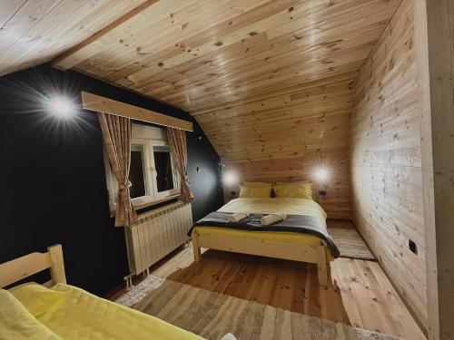 科拉欣Apartman Kruna的木制客房内的一间卧室,配有一张床
