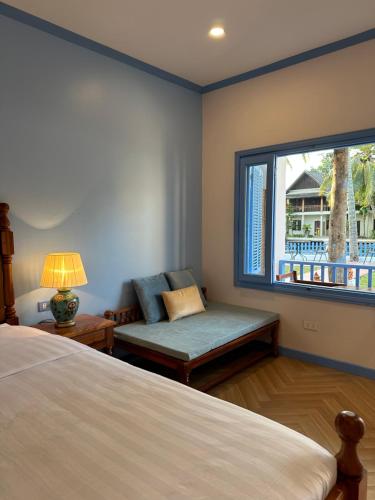 琅勃拉邦Sadakham Hotel的卧室配有床、椅子和窗户。