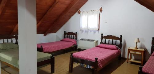 圣拉斐尔DORMIS La Faustina的客房设有三张床、粉色床单和窗户。