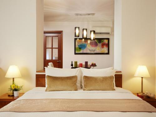 新加坡远东集团悦乐罗伯森码头公寓的一间卧室配有一张带两盏灯的大型白色床。