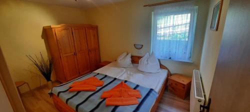 Klein ZickerFerienwohnung Bergholz的一间小卧室,配有带橙色枕头的床