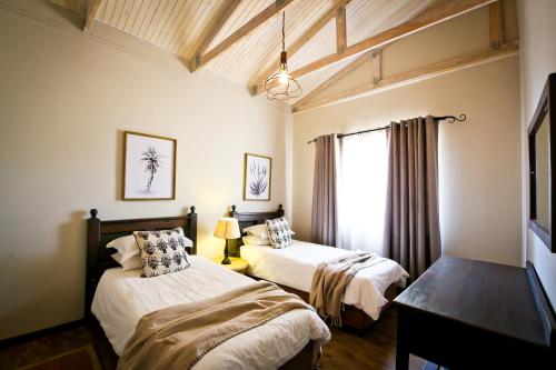 奥奇瓦龙戈欧吉瓦萨法里山林小屋的一间卧室设有两张床和窗户。