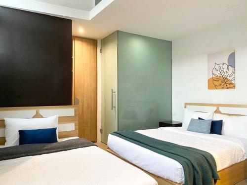 新加坡The Assembly Place, Hotel at Veerasamy的蓝色调的酒店客房内的两张床
