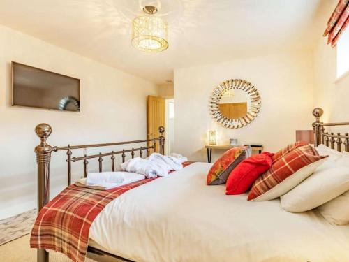 谢伯恩Stags Barn Saxon Maybank的一间卧室配有一张带红色枕头的大床