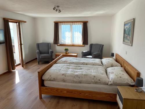 索廖拉索格利纳酒店的一间卧室配有一张大床和两把椅子