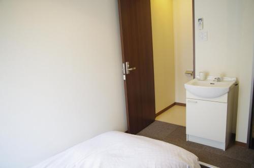 名古屋炭之汤酒店的一间带水槽和床的小浴室