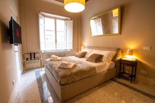卢卡Noble Floor - Luxury Apartments的一间卧室配有一张带镜子的床和一台电视