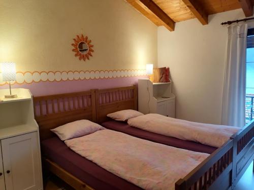 Nandagon Gasthouse的一间卧室设有两张床,墙上设有一面镜子