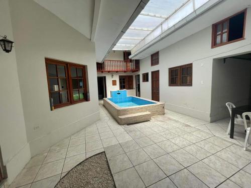 Los Baños del IncaHospedaje Casa Blanca Beach的一间大房间,房子里设有游泳池