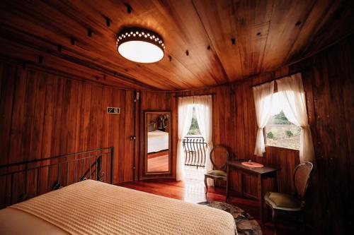 本图贡萨尔维斯Pipas Terroir - Vale dos Vinhedos - Pousada Temática的木制客房内的一间卧室,配有一张床
