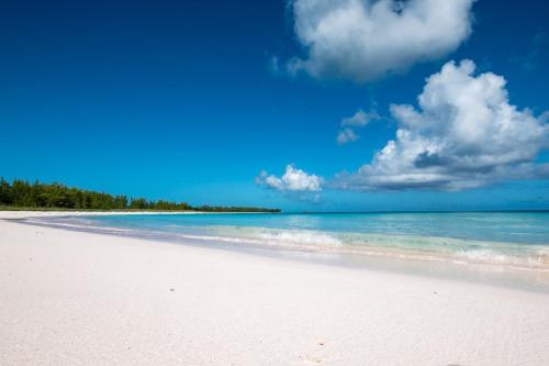 总督港Mon Soleil home的一片拥有大海、蓝天和云的海滩