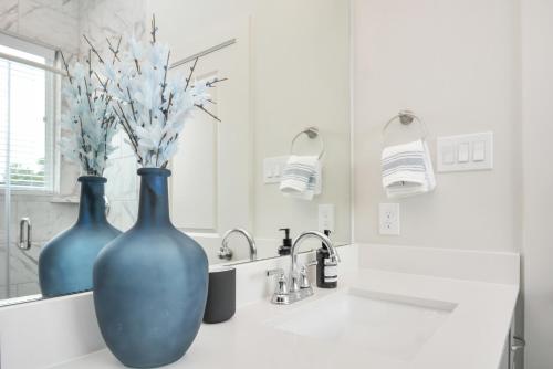 休斯顿Casa Azure - New Modern 3 BR, Med Center, NRG, UH的浴室的柜台上有两个蓝色花瓶