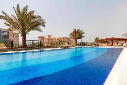 迪拜1 Bed Apartment with Sea View, Pool, Gym & Free Parking in Dubai Marina的一座种植了棕榈树和建筑的大型蓝色游泳池