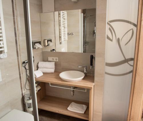 Wettelsheim加思索夫尊金德恩兰姆酒店的一间带水槽和镜子的浴室