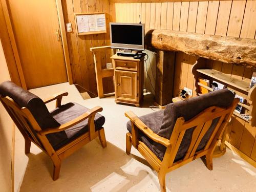 楚奥茨Chesa Margadant的客厅配有两把椅子和电视
