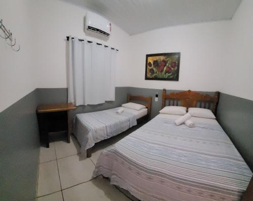诺布里斯Casa Flor do Ipê Homes的一间卧室配有两张床和空调。