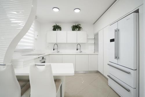 埃拉特Golf Residence By Sun and View的白色的厨房配有白色橱柜和水槽