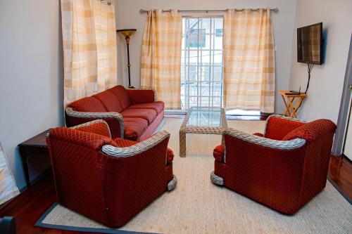 乔治敦JR Apartments的客厅配有两把椅子和一张沙发