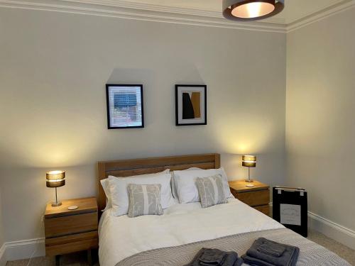 锡米尔Traditional Cottage in West Kilbride Village的一间卧室配有一张带2个床头柜和2盏灯的床。