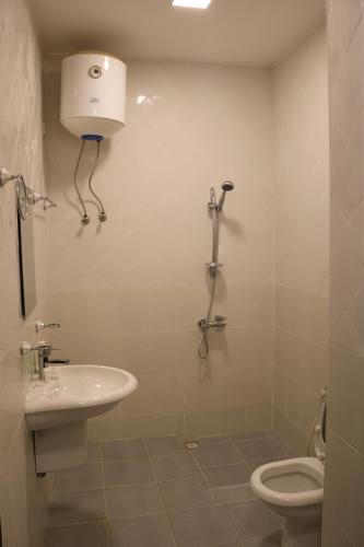 锡卜Al-Mwadda Hotel的白色的浴室设有卫生间和水槽。