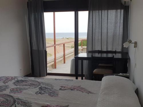 埃斯特角城Hotel Playa Chihuahua的一间卧室配有一张床,享有海滩美景
