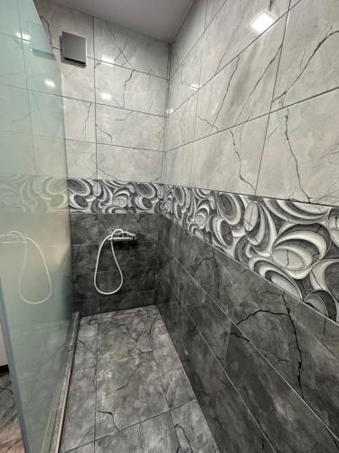 第比利斯KING SUITE APARTMENT lN TBILISI的浴室设有马赛克瓷砖墙和淋浴。