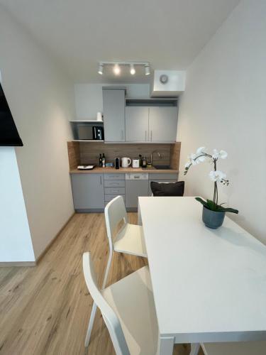维也纳#Family & Friends# Ruhig, grün, gleich in der City的厨房配有白色的桌子和白色的椅子