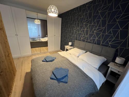 科沙林Apartament Studio Centrum的一间卧室配有一张大床,上面有蓝色的毛巾