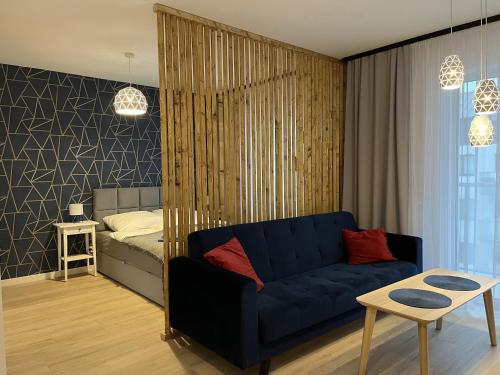 科沙林Apartament Studio Centrum的客厅配有蓝色的沙发和床。