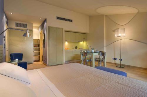 佛罗伦萨Pop公寓式酒店的一间卧室配有一张床铺和一张桌子,还设有一间厨房