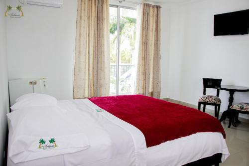 圣何塞德尔瓜维亚雷Centro Vacacional Las Palmas的卧室配有一张带红色毯子的白色床