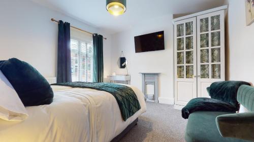 曼斯菲尔德Princely House Corporate, business & family Home的一间卧室配有一张床、一张沙发和一台电视。